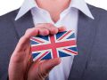 Mann im Anzug hält Visitenkarte mit Britischer Flagge